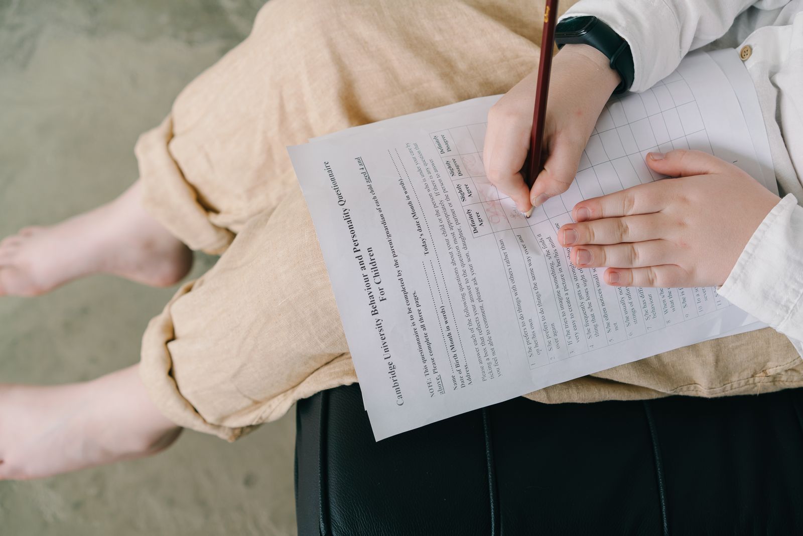 A parent's hands annotating a printed checklist