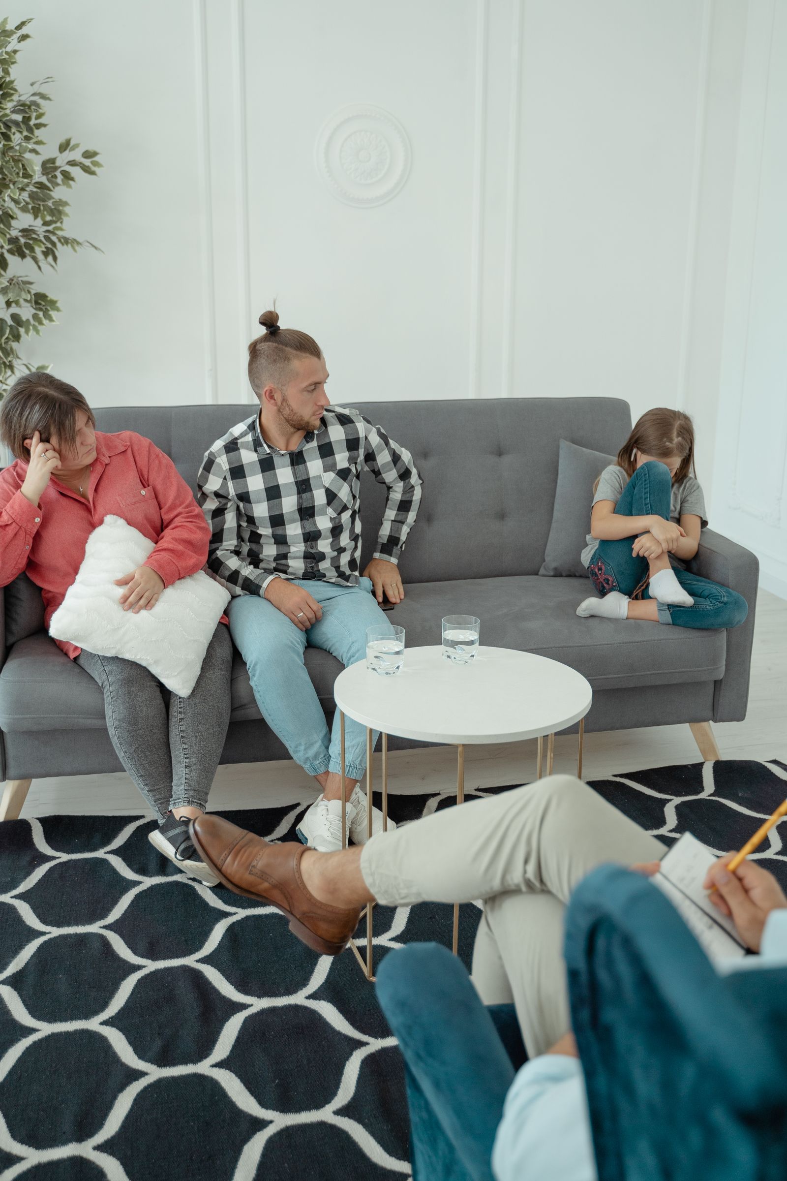 A family on a sofa in the evening, children absorbed in screens