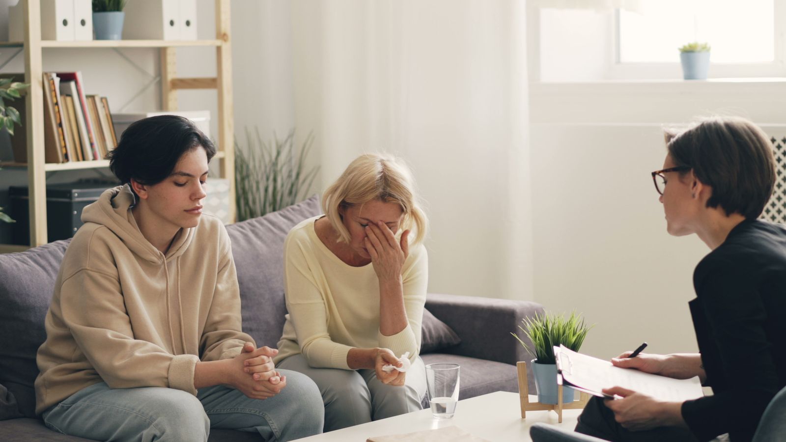 Two parents talking with a clinician who is taking notes