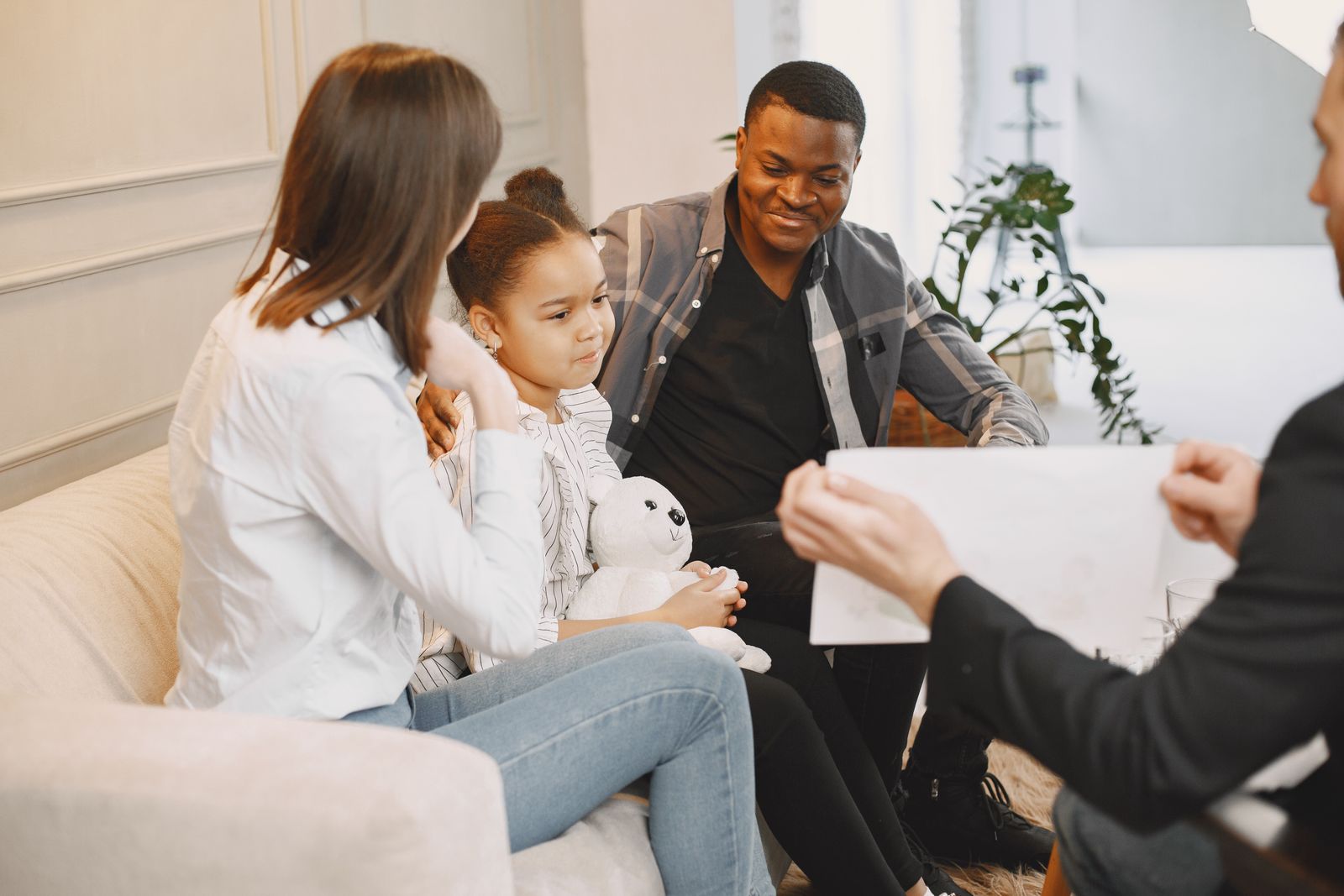 A clinician handing an assessment report to a parent and child